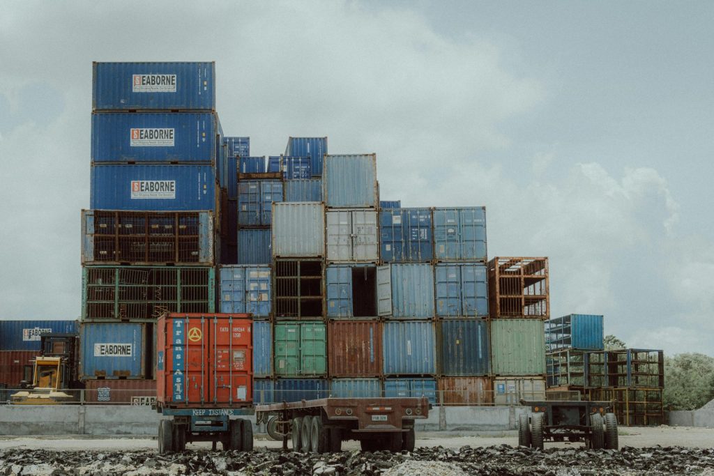 Des conteneurs maritimes colorés empilés dans un port illustrent la logistique et le commerce mondiaux.